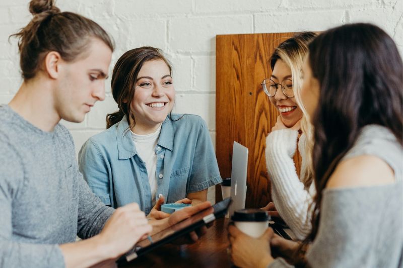 Four students studying and talking around a table 