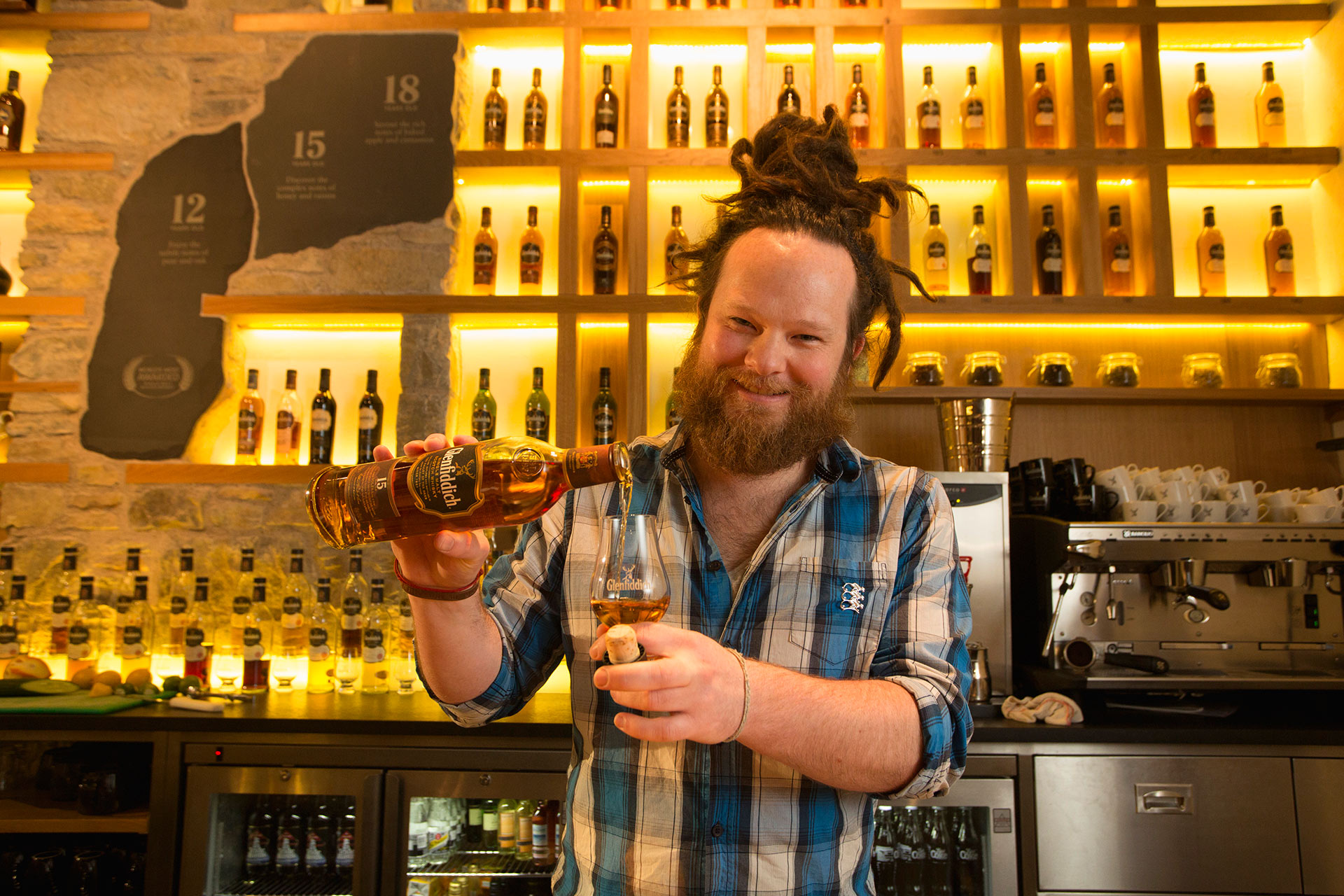 A person holding a bottle of Glenfiddich whisky 